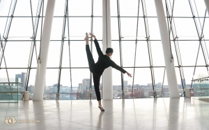 Dansaren Helen Li har en eftermiddagspaus i lobbyn på Kansas Citys Kauffman Center for the Performing Arts och kopplar av medan hon utför páng tuǐ tǎng shēn (旁腿躺身) eller ”ben åt sidan med lutande kropp”. (Foto av dansaren Diana Teng)  