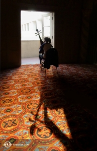 Inne i den svala lobbyn på Phoenix Orpheum Theatre övar Liang Yu på sin pipa, den fyrsträngade kinesiska ”lutan”. (Foto av projektionist Annie Li)