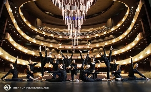 Shen Yun World Company poserar i Winspear Opera House i Dallas, Texas. Teatern är designad som en 2000-talsversion av ett traditionellt operahus. Teaterns enorma infällbara ljuskrona hänger i bakgrunden.