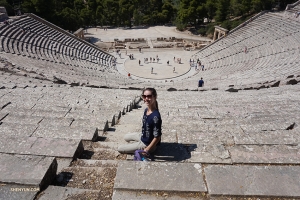 Daniella sitter i den forntida teatern Epidaurus. Hon säger att det är riktigt coolt att vara i en gammal teater i landet där teatern föddes.